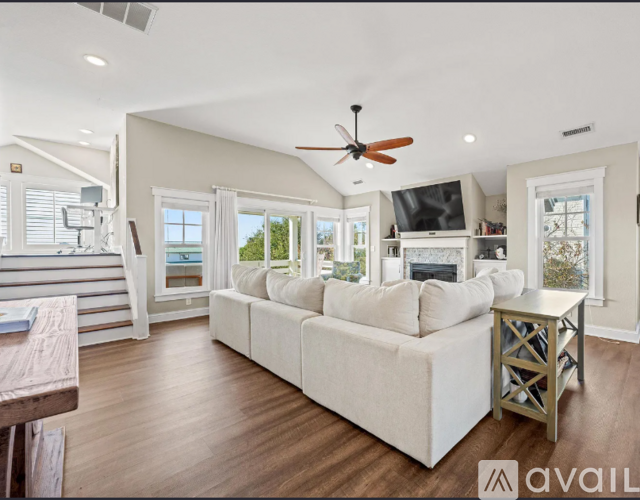 A living room with a white couch and a ceiling fan.