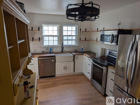A kitchen with wooden floors and stainless steel appliances.