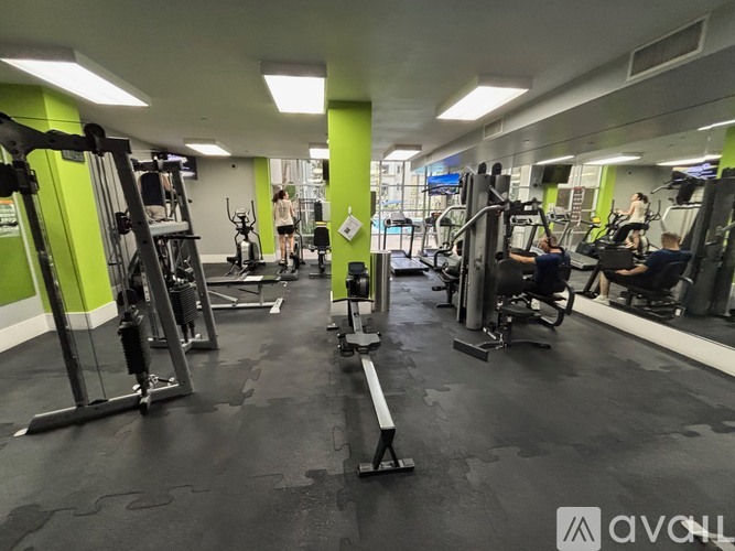 A gym with people working out and various exercise equipment.