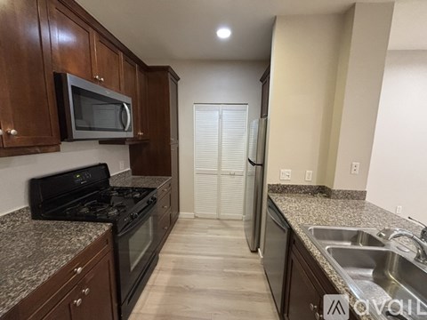 A kitchen with brown cabinets and a black stove top oven.