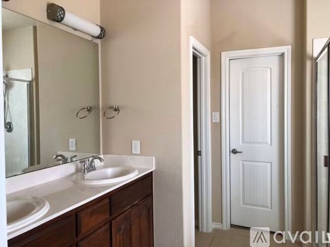 A bathroom with a white sink and a white door.