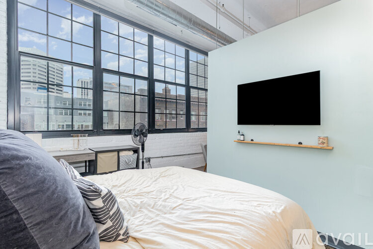 A bedroom with a large bed and a flat screen TV mounted on the wall.