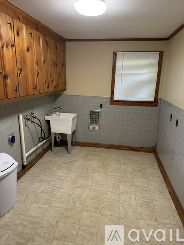 A bathroom with a toilet, sink, and wooden cabinets.