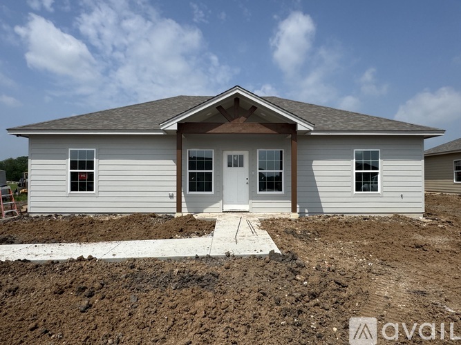 A house under construction with a white front door and brown trim.