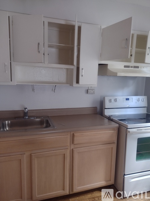 A kitchen with wooden cabinets and a stainless steel oven.