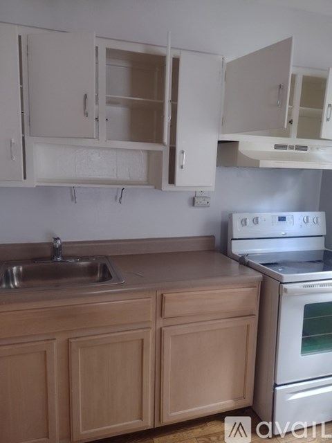 A kitchen with wooden cabinets and a stainless steel oven.