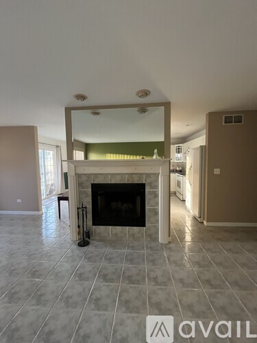 A living room with a fireplace and a mirror above it.