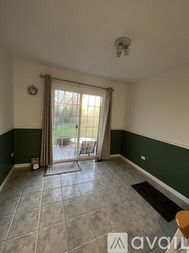 A room with a tiled floor and a sliding glass door leading to a patio.