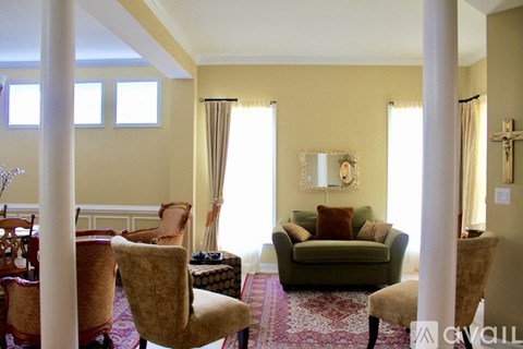 A living room with a green couch and a mirror on the wall.