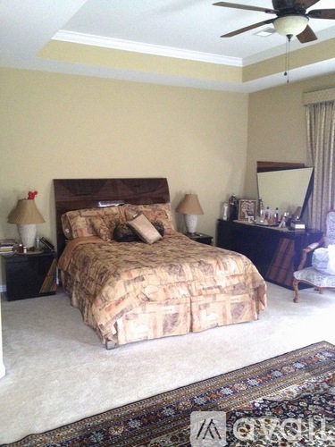 A bedroom with a bed, nightstands, and a ceiling fan.