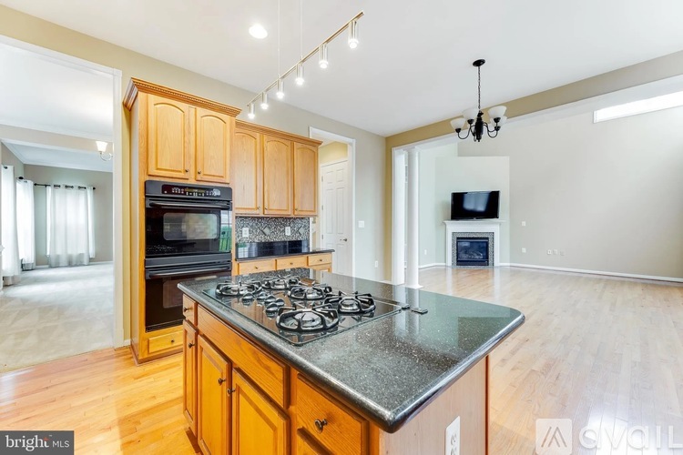 A kitchen with wooden cabinets and a granite countertop.