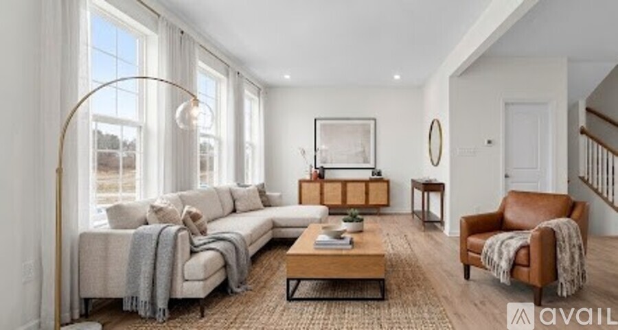 A living room with a large sectional sofa, a coffee table, and a side table with a lamp.
