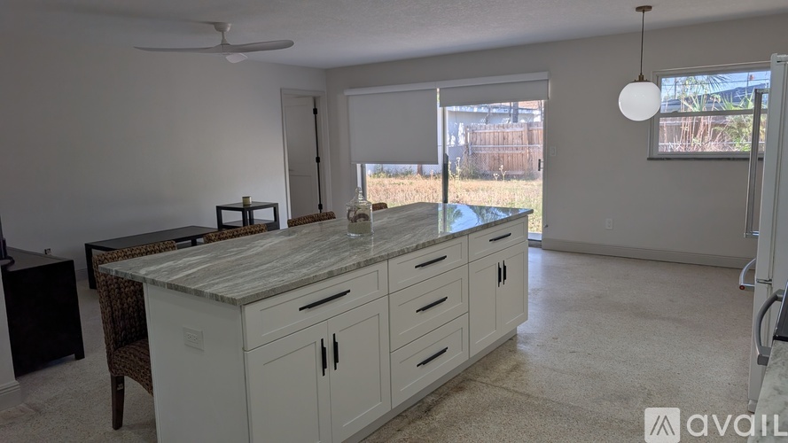 A kitchen with white cabinets and a countertop is available for rent.