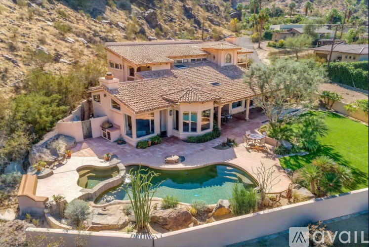 A large house with a pool in the middle of a desert.