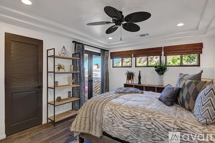 A bedroom with a large bed and a ceiling fan.