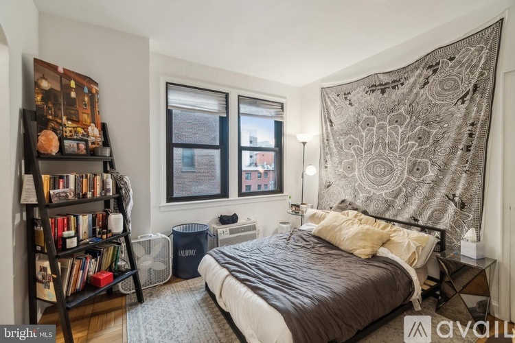 A bedroom with a large bed and a bookshelf filled with books.
