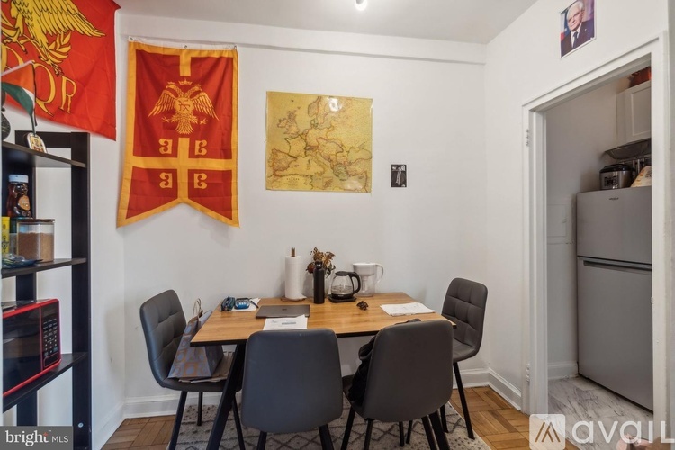 A dining room with a table set for two and a flag hanging on the wall.