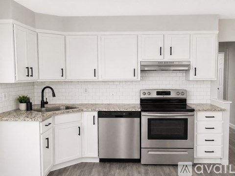 A kitchen with white cabinets and a granite countertop.