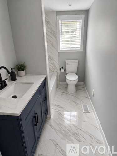 A bathroom with a white sink and a white toilet.