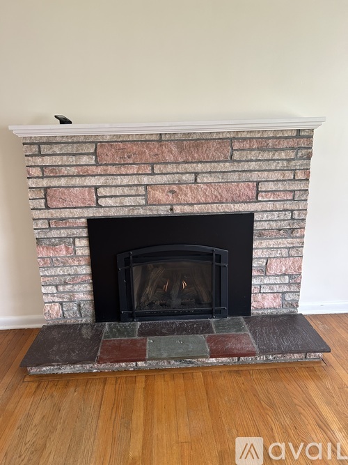 A fireplace with a brick surround and a black firebox.