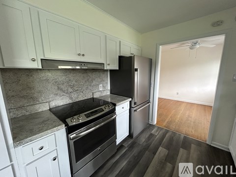 A kitchen with white cabinets and a black stove top oven.