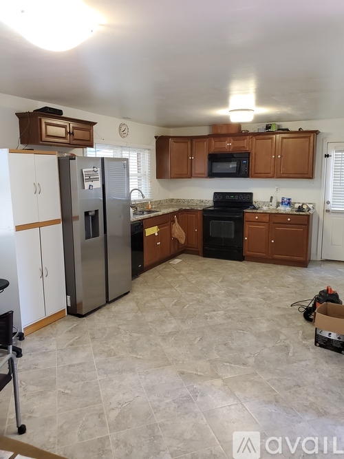 A kitchen with a refrigerator, microwave, oven, and cabinets.