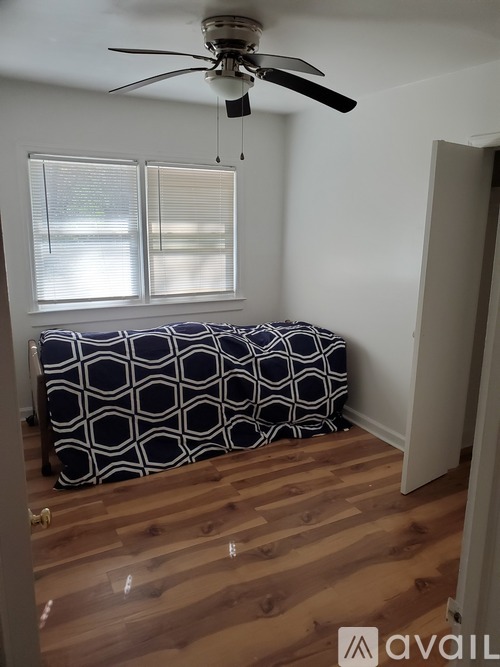 A room with a bed and a ceiling fan.