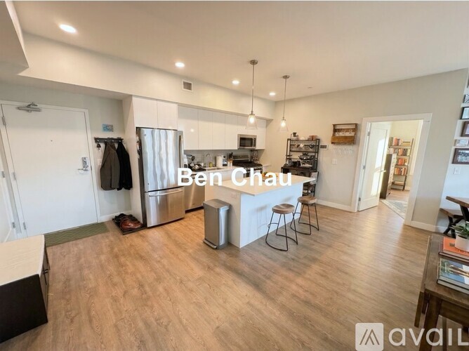 A kitchen with a bar stool and a fridge.