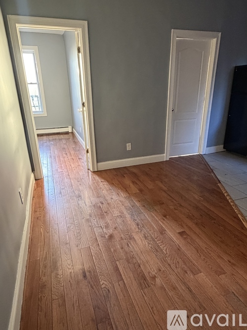 A room with wooden flooring and two white doors.