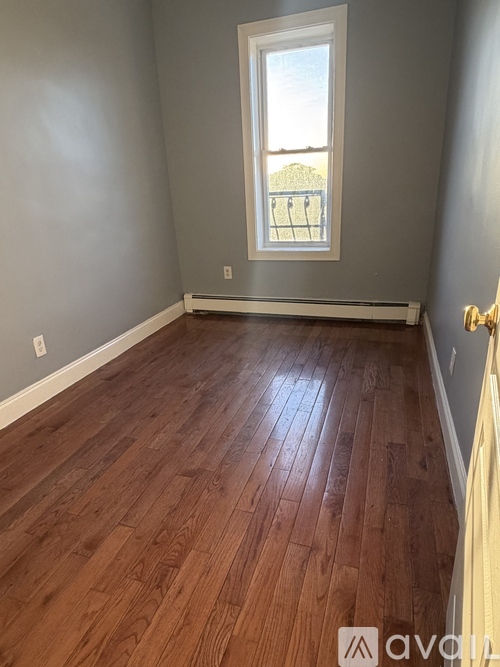 A room with wooden flooring and a window.