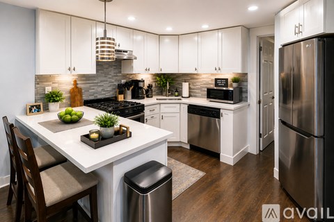 A modern kitchen with a white island and stainless steel appliances.