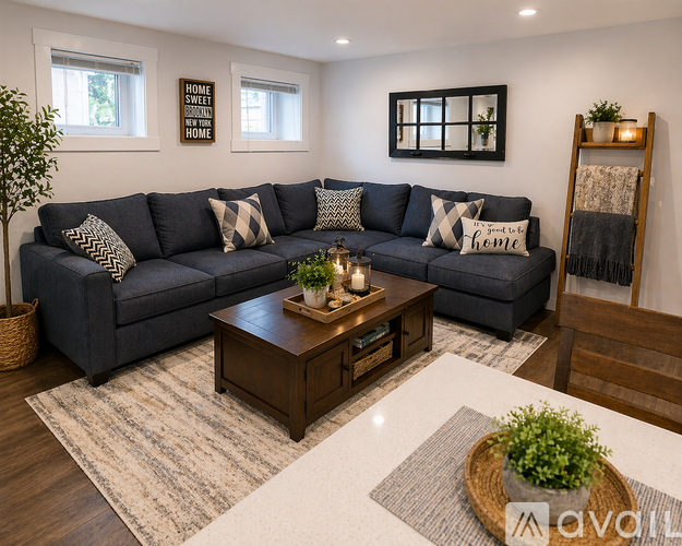 A living room with a grey couch, a coffee table, and a rug.