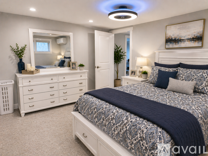 A bedroom with a bed, dresser, and mirror.