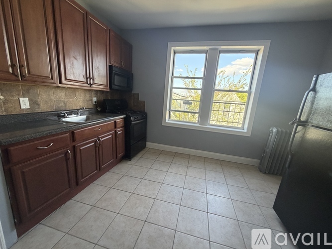 A kitchen with brown cabinets and a black stove top oven.