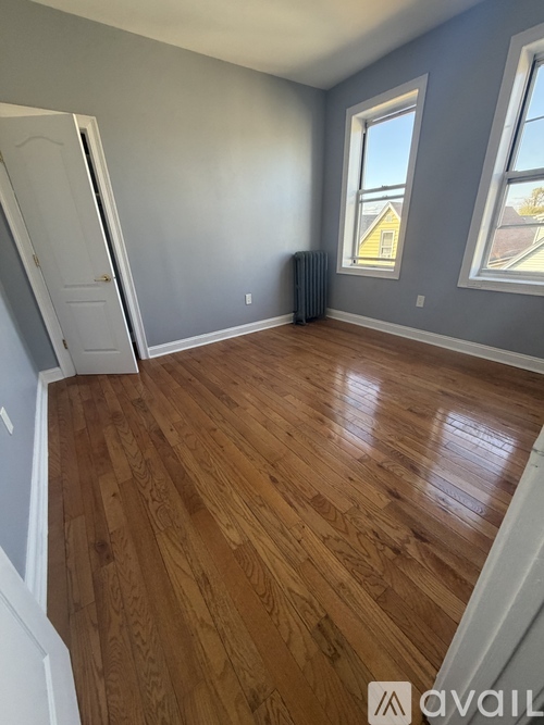 A room with wooden flooring and a window.