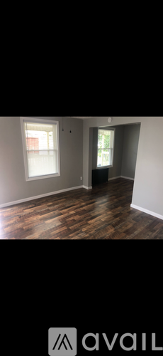 A room with wooden flooring and white walls.