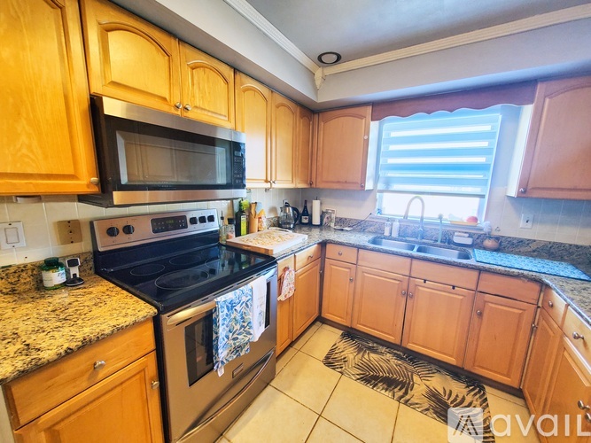 A kitchen with wooden cabinets and granite countertops.