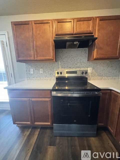 A kitchen with wooden cabinets and a black stove top oven.