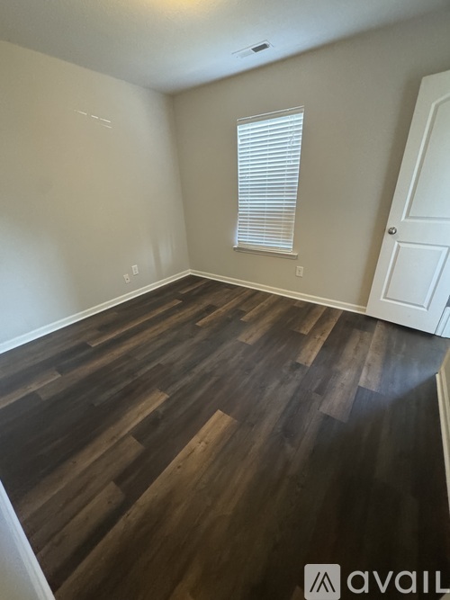 A room with wooden flooring and a white door.