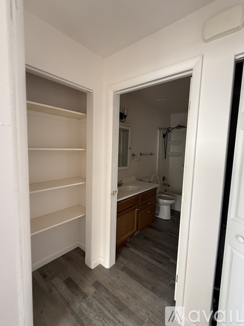 A white door is open to a bathroom with a toilet and sink.
