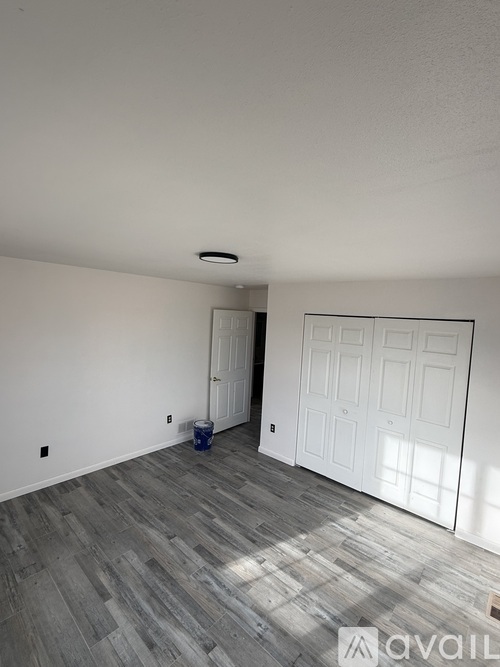 A room with a wooden floor and a white door.