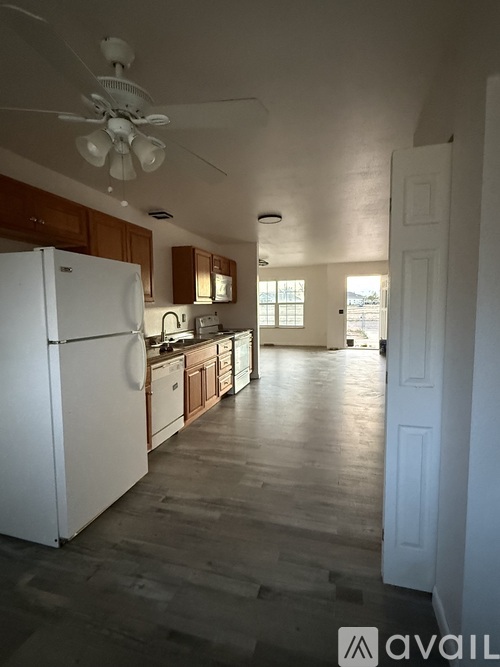 A kitchen with white appliances and wooden cabinets.