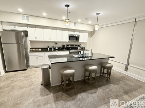 A kitchen with a refrigerator, stove, and bar stools.