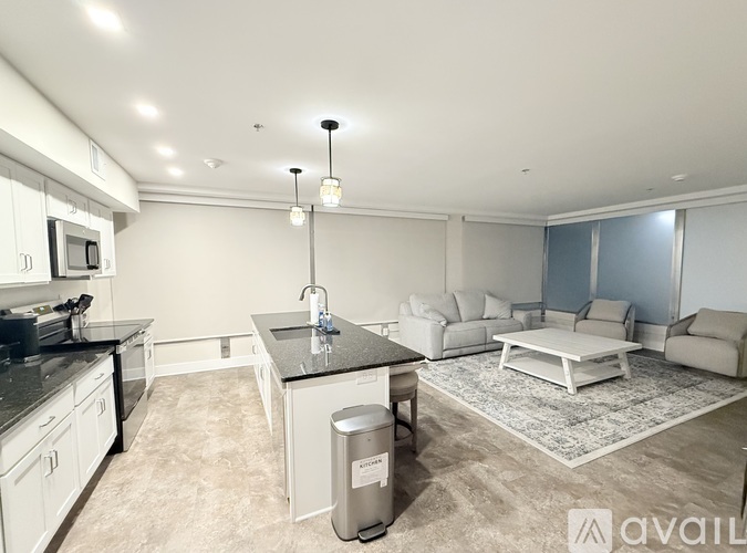 A modern kitchen with a black countertop and white cabinets.
