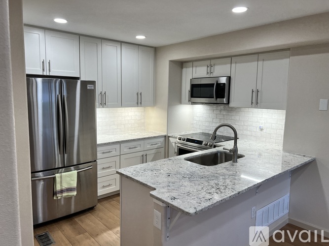 A kitchen with a granite countertop and stainless steel appliances.