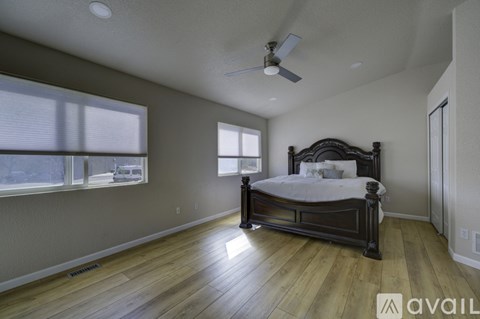 A bedroom with a large bed and a ceiling fan.