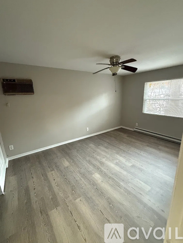 A room with a ceiling fan and a window with blinds.