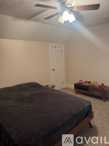 A bedroom with a bed, a ceiling fan, and a wooden bench.