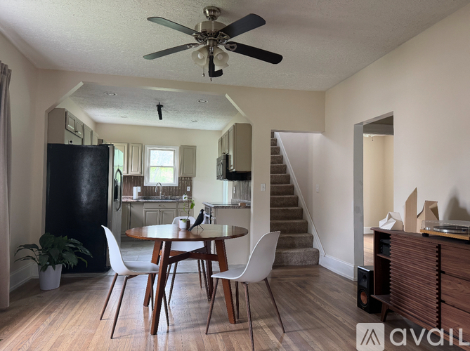 A dining room with a table and chairs and a ceiling fan.