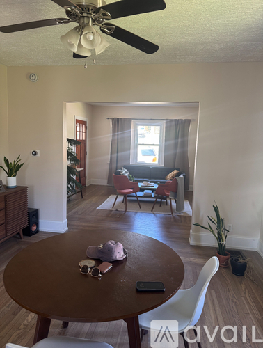 A living room with a brown table and white chairs.